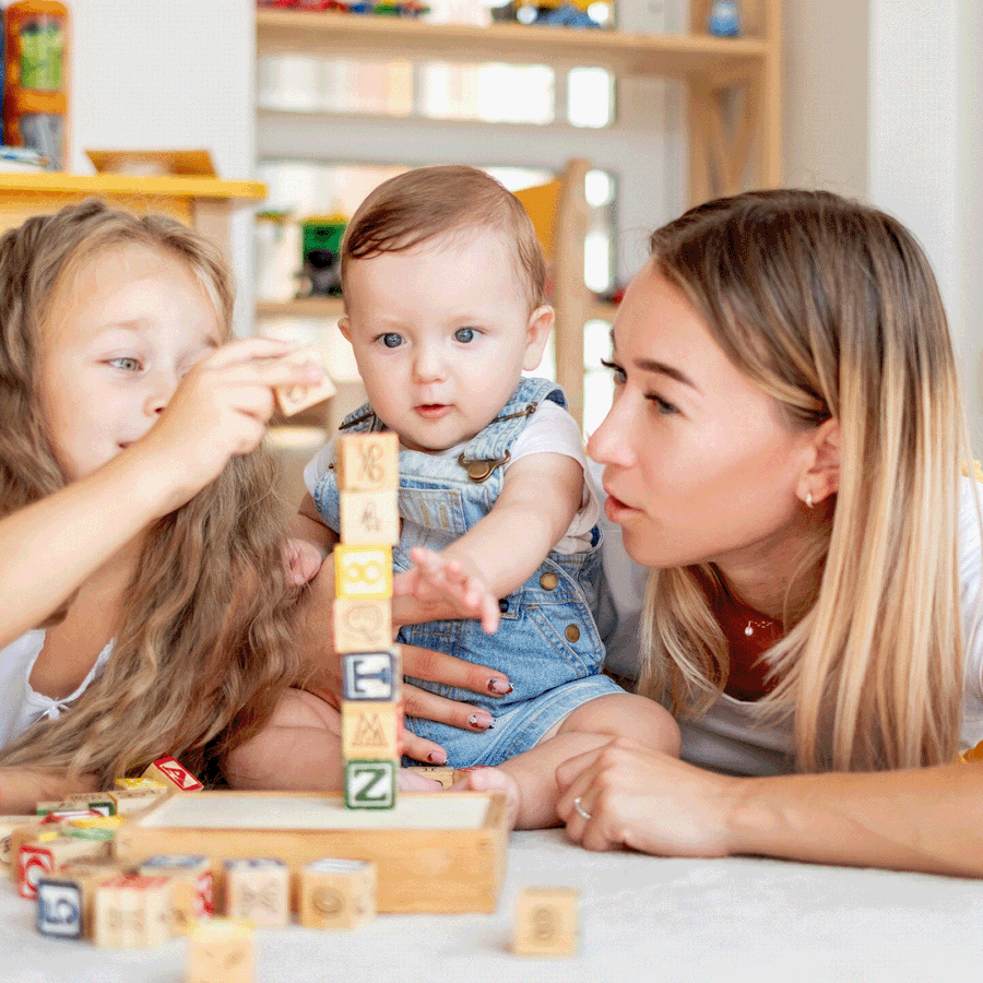 child baby and teenager playing blocks together